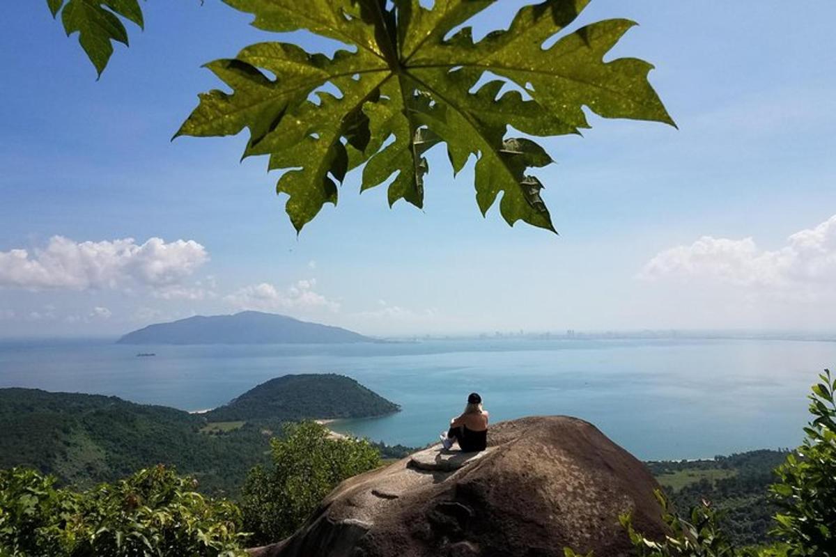a person sitting on a rock looking at the water