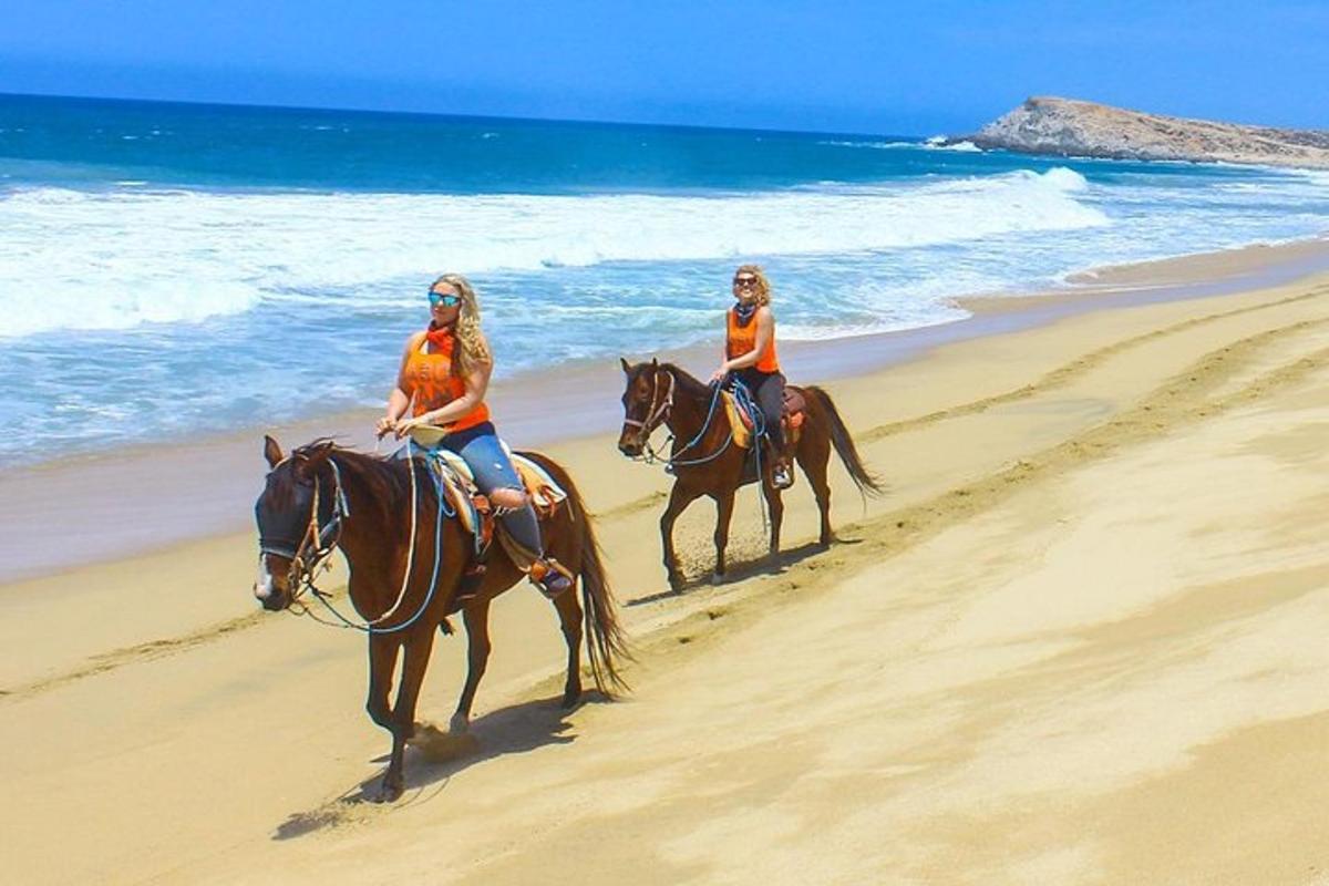 due donne stanno cavalcando sulla spiaggia