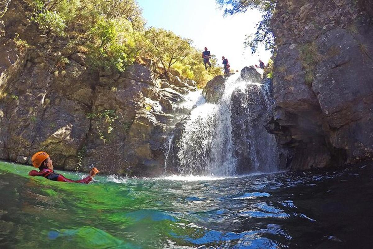 maður í kajak fyrir framan foss