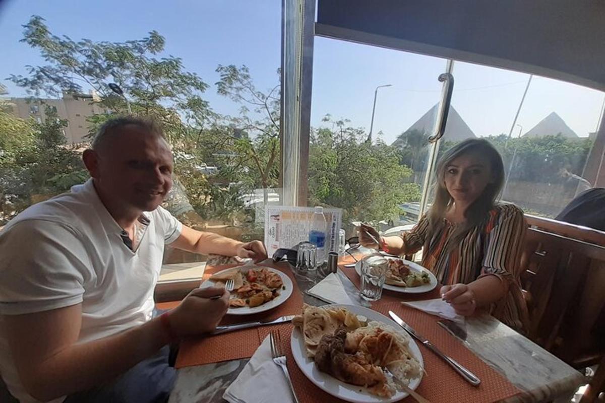 un uomo e una donna seduti a un tavolo che mangiano cibo