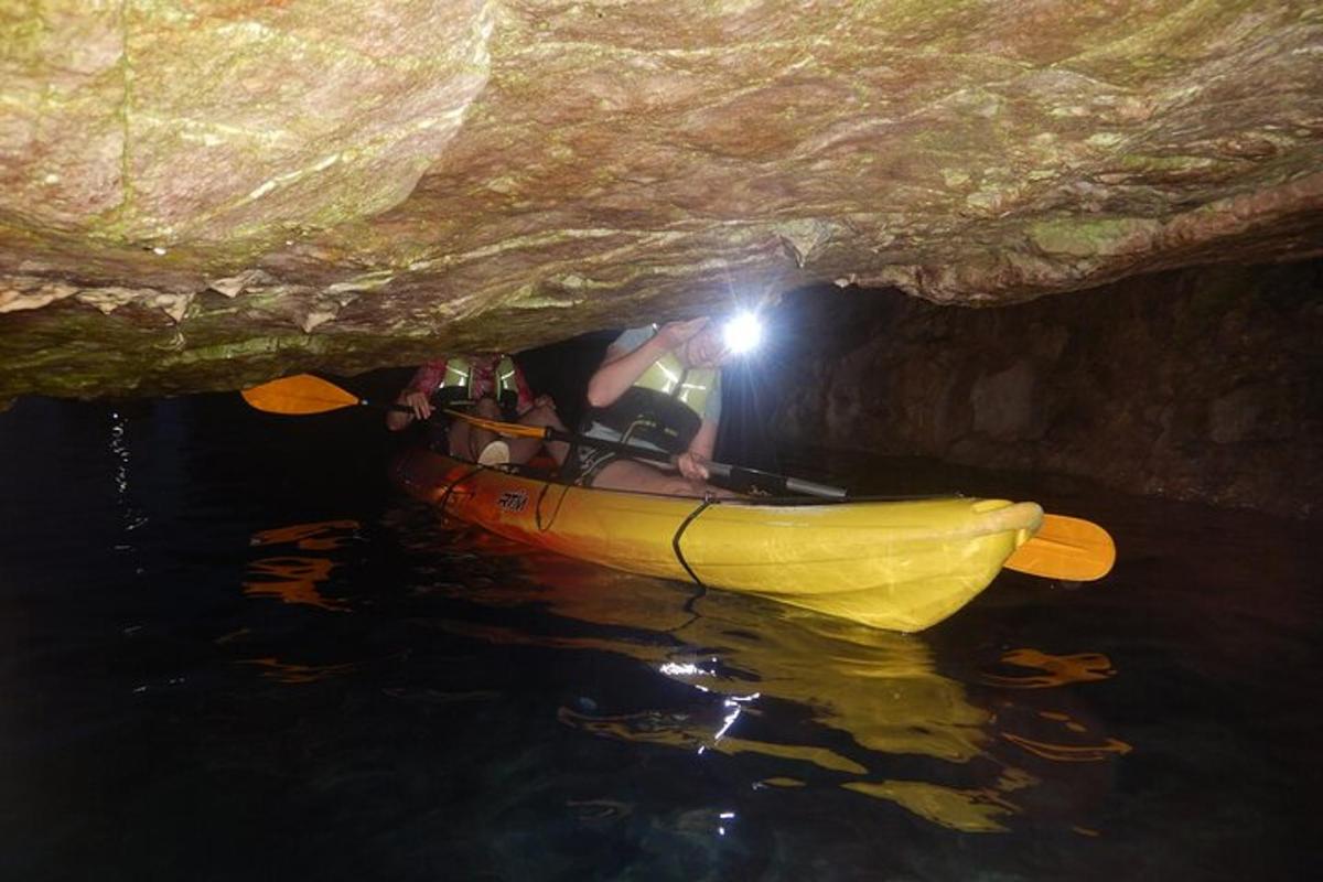 uma pessoa em um caiaque amarelo em uma caverna