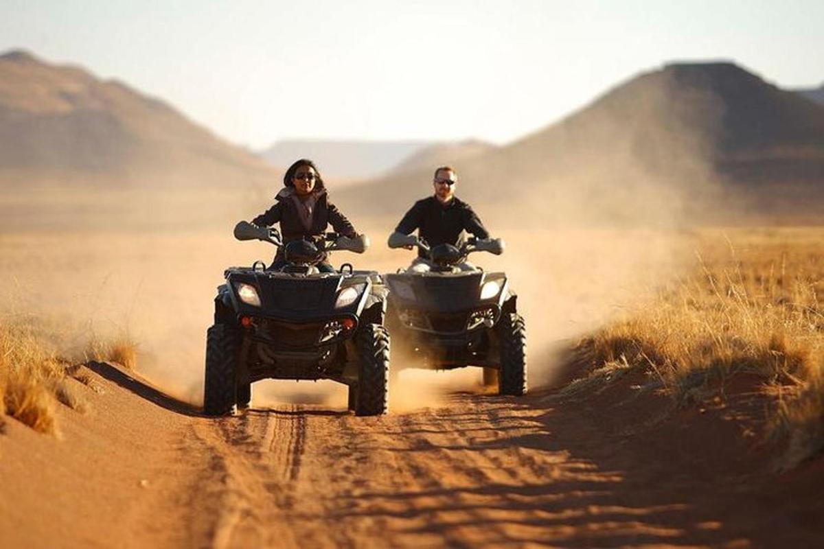 două persoane care călătoresc pe ATV-uri pe un drum de pământ