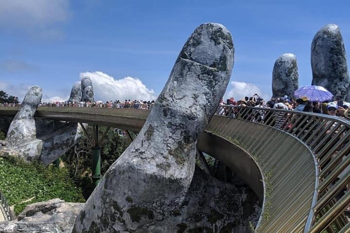 tangan batu besar menghulurkan ke atas jambatan