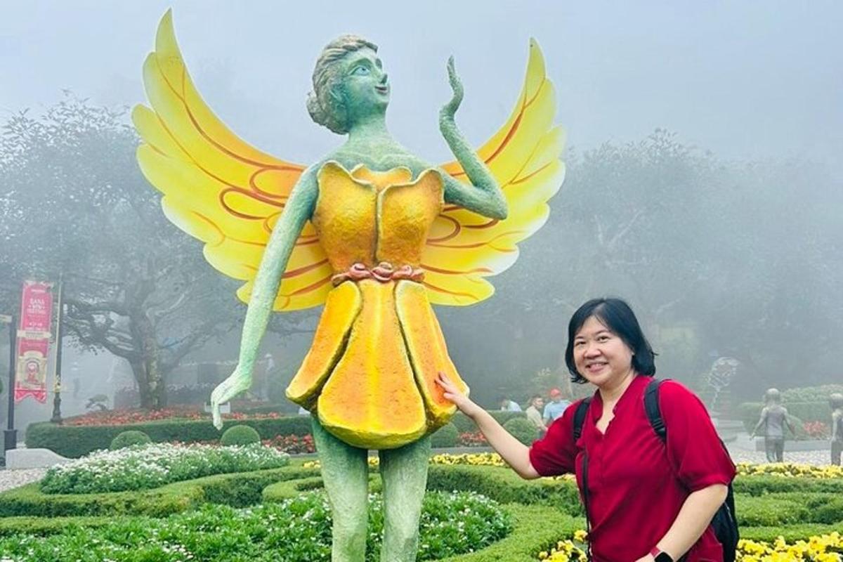 en kvinne som står ved siden av en statue av en fe