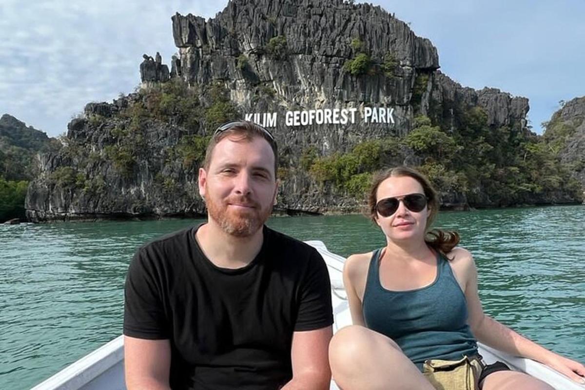 seorang lelaki dan seorang wanita duduk di atas bot di dalam air
