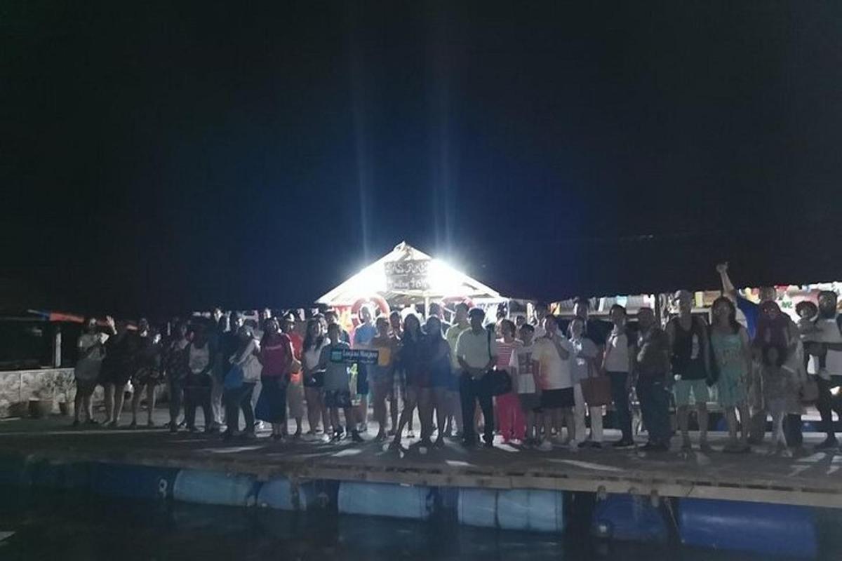 skupina ljudi, ki ponoči stojijo pod šotorom