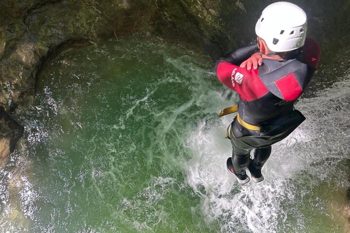 un home està saltant a l'aigua d'un riu
