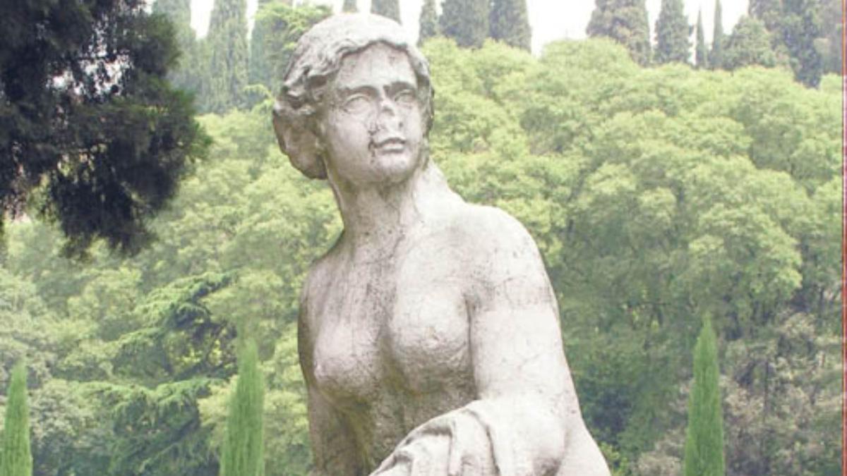 uma estátua de uma mulher em pé em frente às árvores