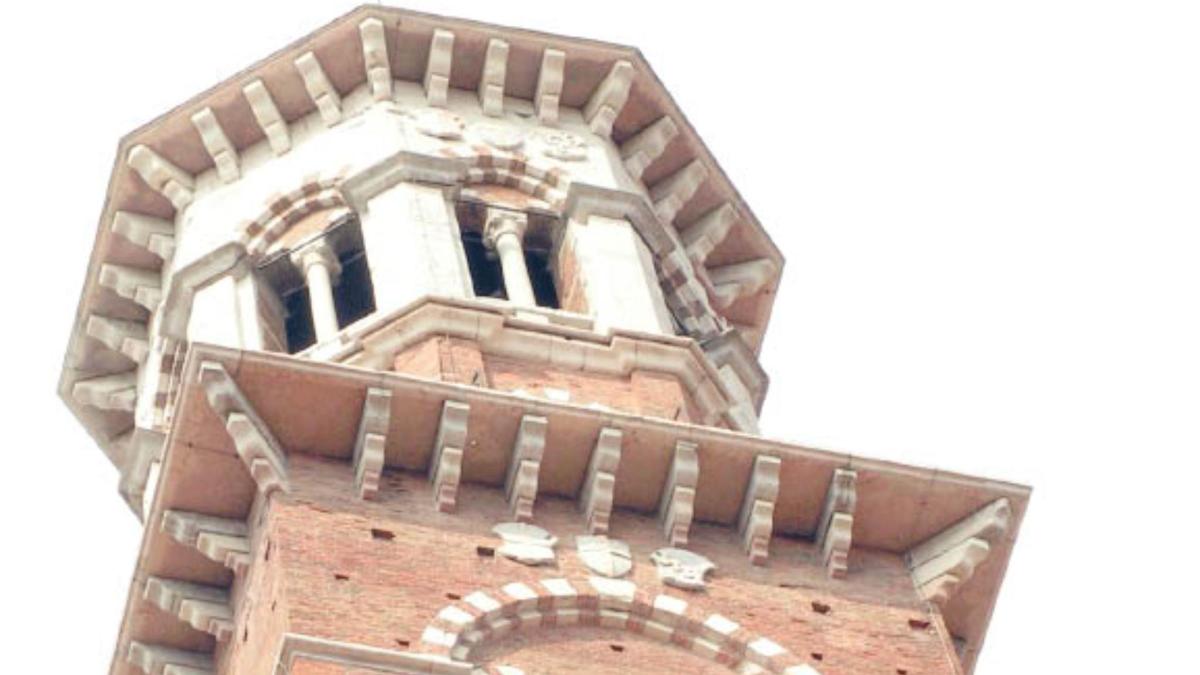um prédio alto de tijolos com uma torre de relógio