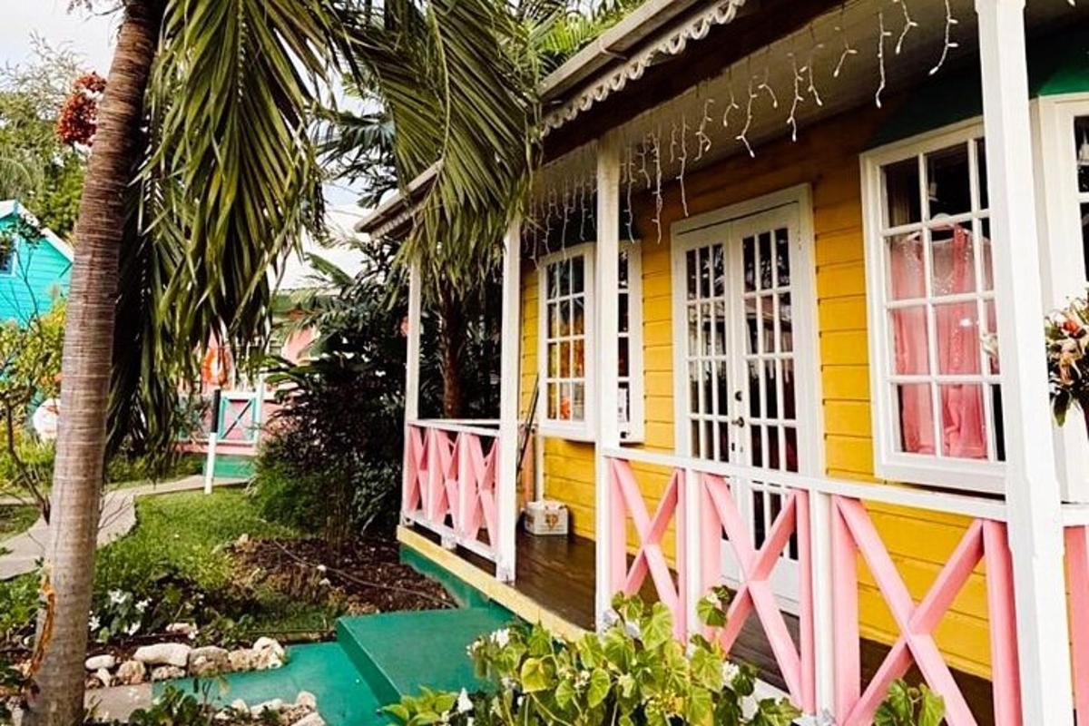 a yellow and pink house with a palm tree