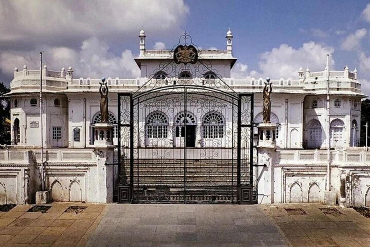 a gate in front of a white building with a clock