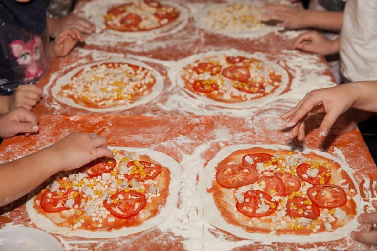 hópur fólks að búa til pizzur á borði