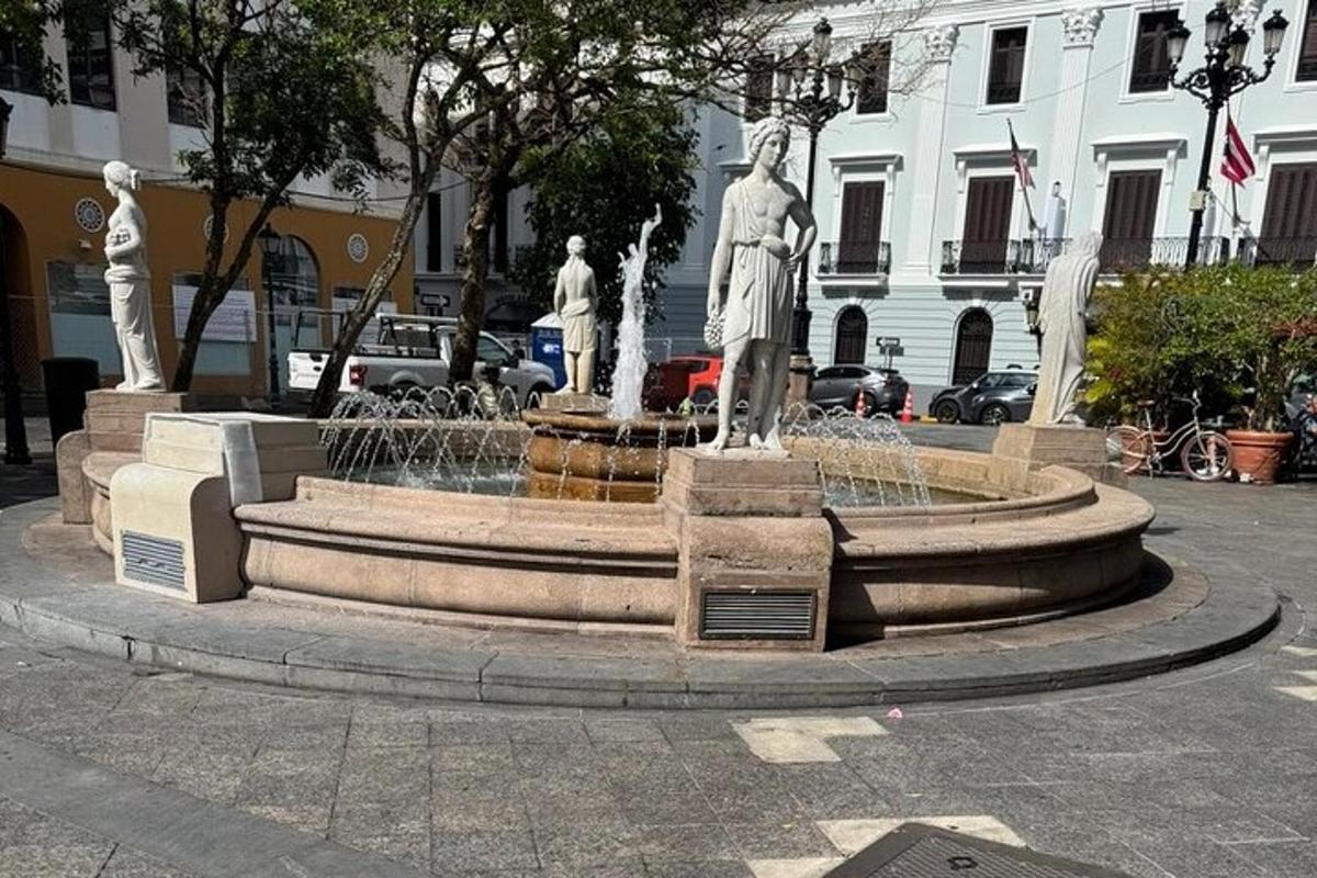 a fountain with three statues in a city
