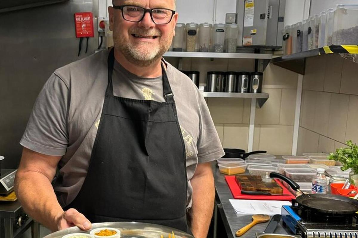 a man in a kitchen holding a plate of food