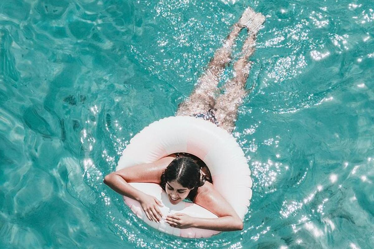 một người phụ nữ nằm trong một chiếc phao dưới nước