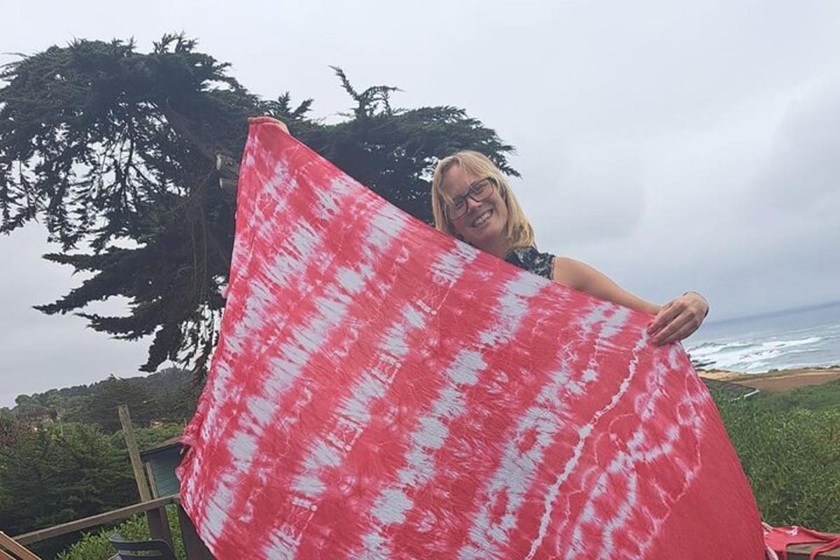 a woman is holding a red surfboard