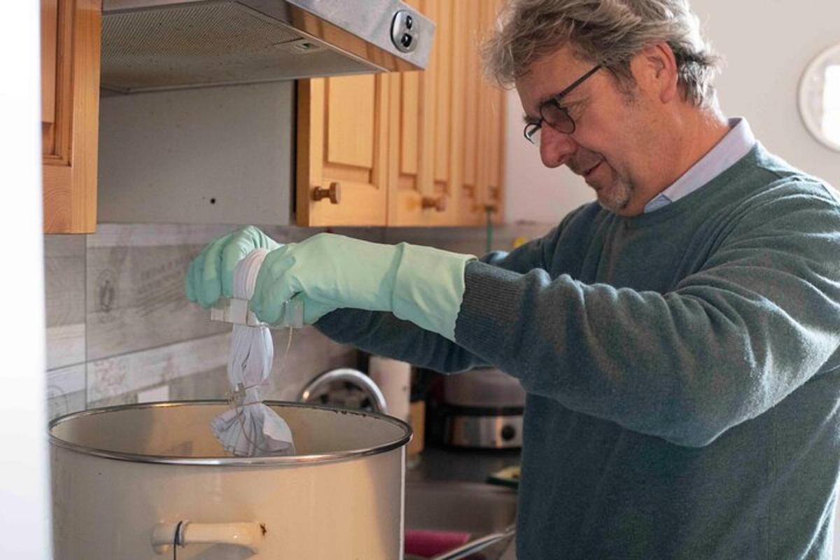 a man in a kitchen preparing food in a pot