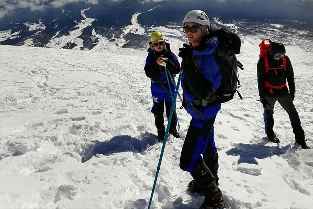 skupina lidí na vrcholu zasněžené hory