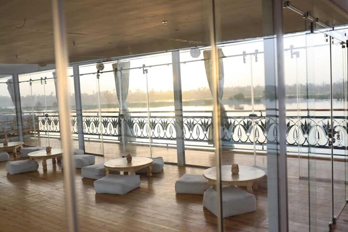 una stanza con tavoli e sedie davanti a una grande finestra