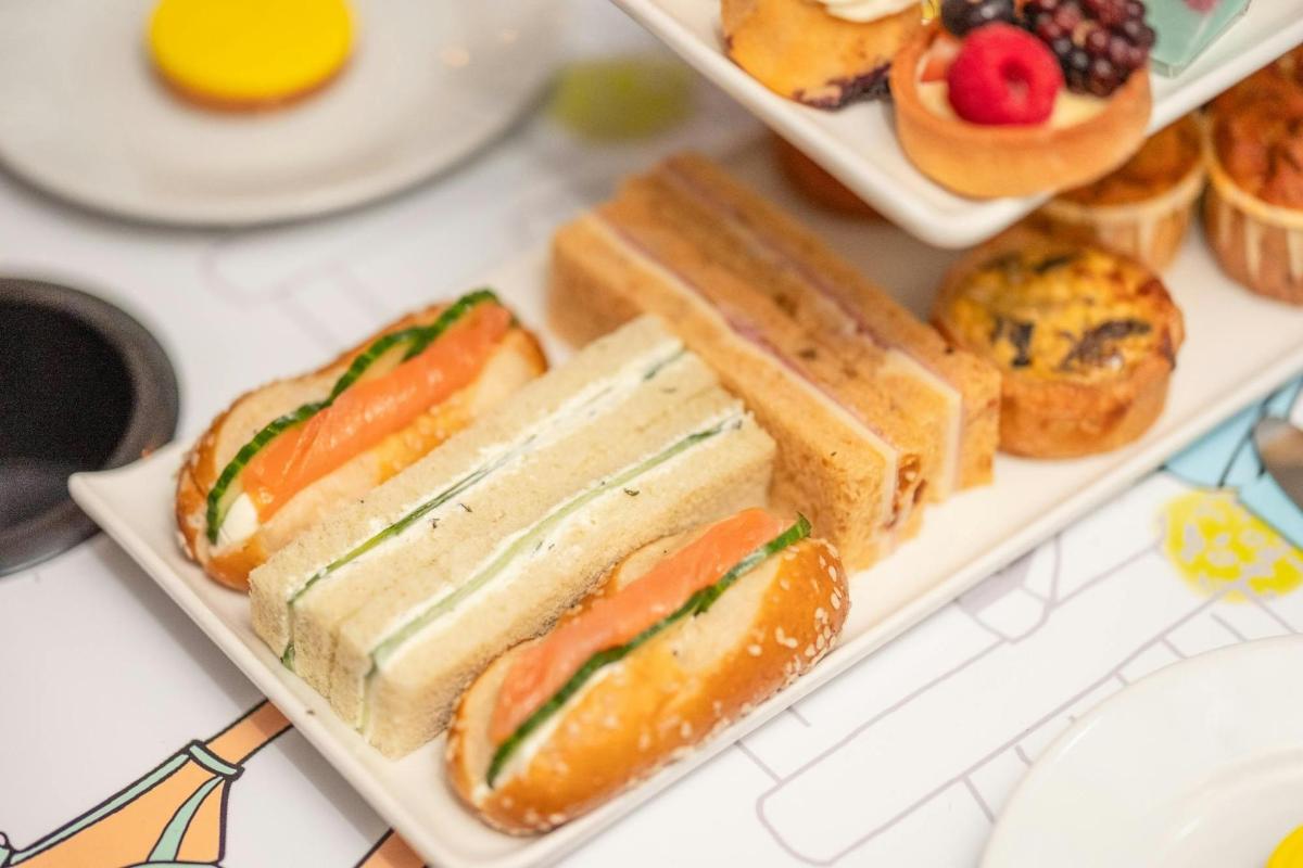 Un plato de sándwiches y pasteles en una mesa.
