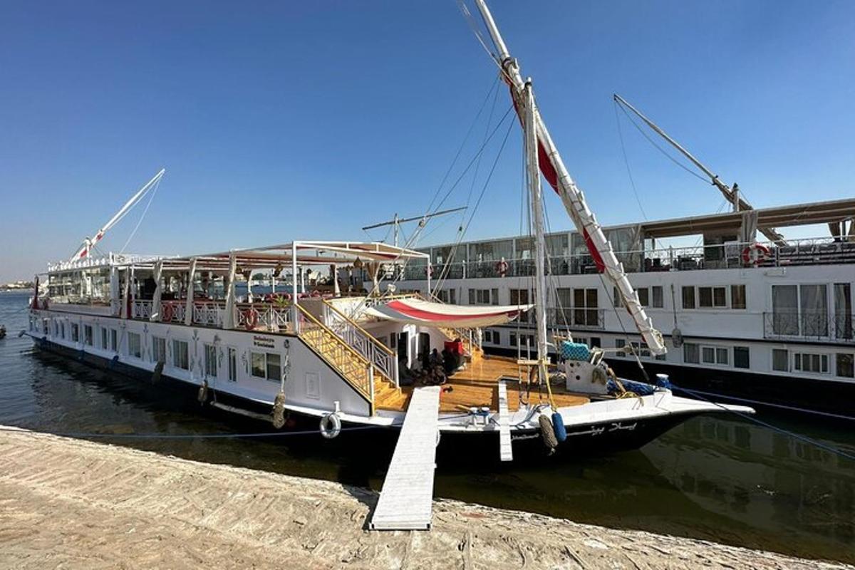 een grote boot ligt aangemeerd aan een steiger