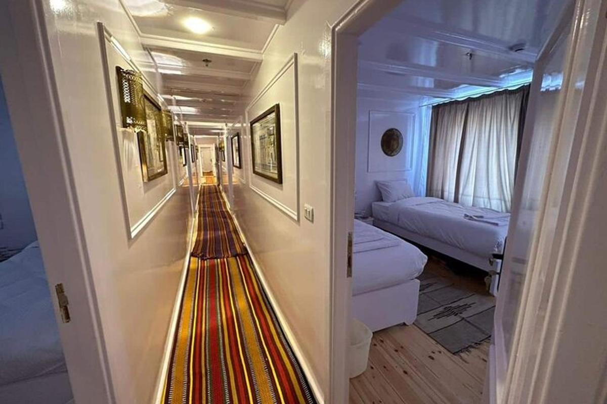 a hallway of a cruise ship with a room with two beds