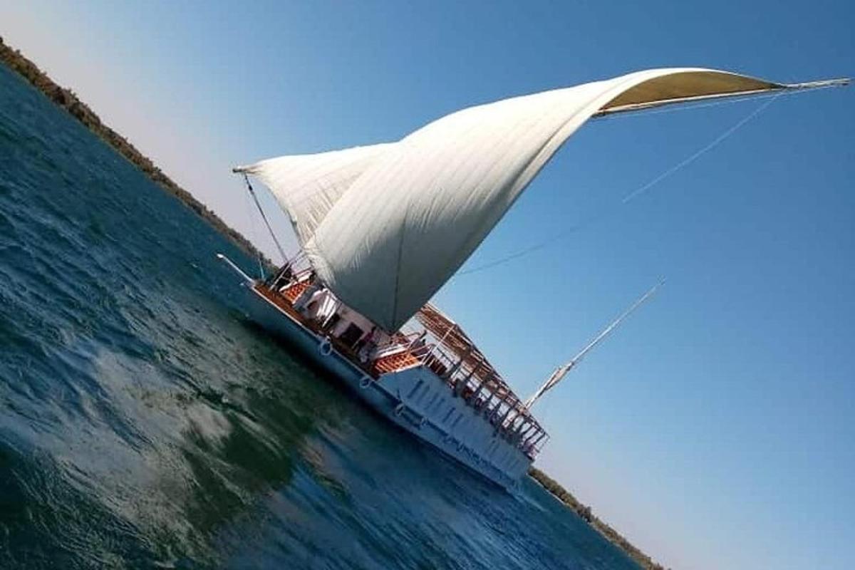 una barca con una grande vela bianca nell'oceano