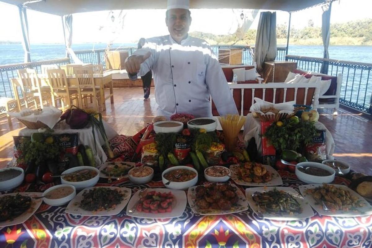 uno chef in piedi davanti a un tavolo di cibo