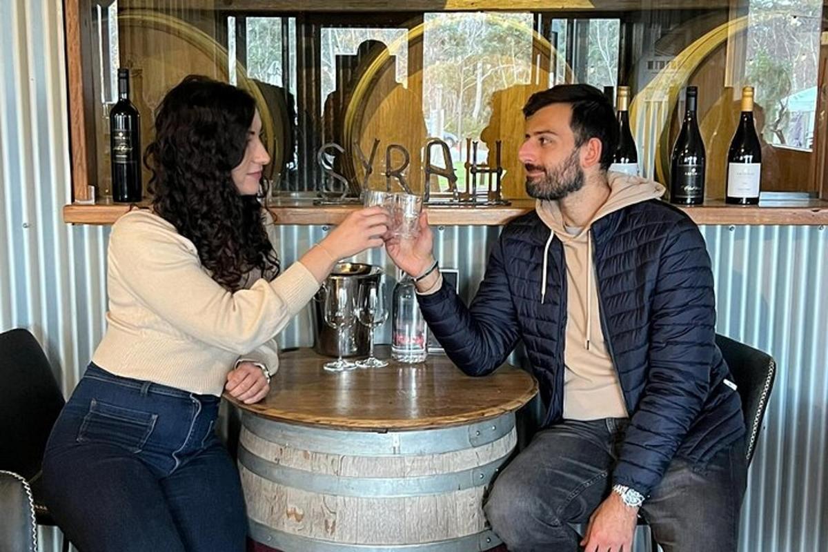 um homem e uma mulher sentados em um bar com um copo