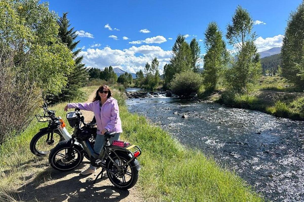žena sedící na motorce u řeky