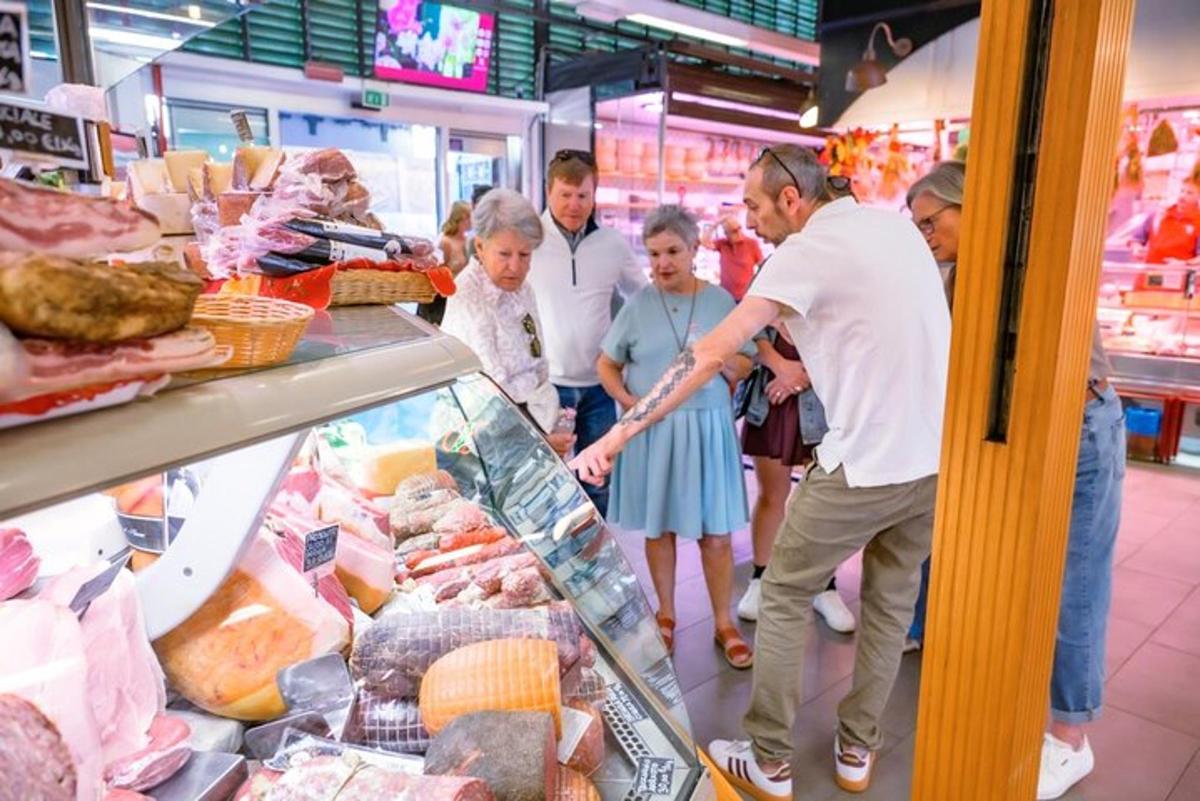skupina lidí si prohlíží maso v obchodě s potravinami
