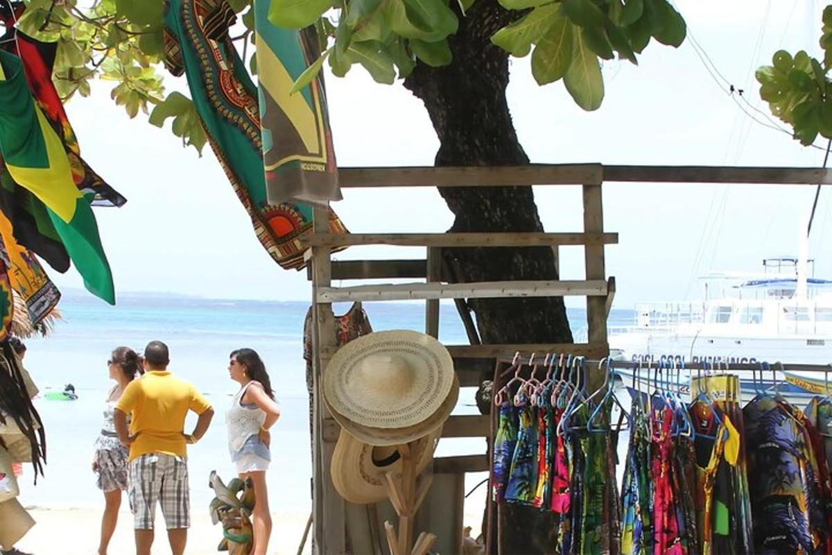 un grup de persones dretes a la platja al costat d'un arbre