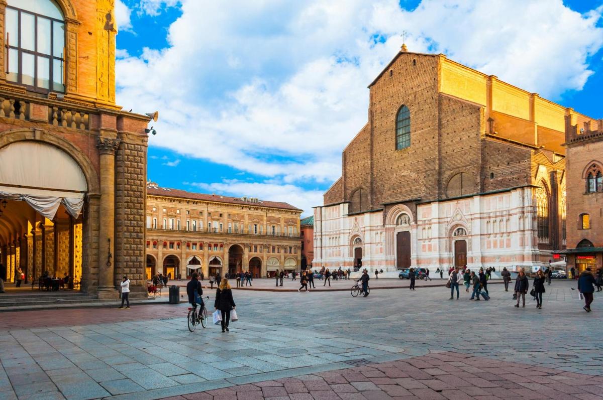 un gruppo di persone che camminano in una piazza di un edificio