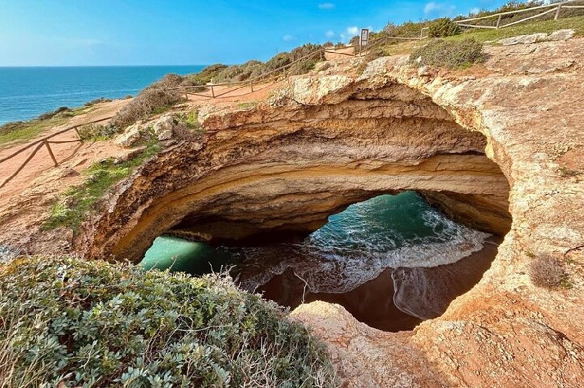 a cave in the side of a cliff with the ocean