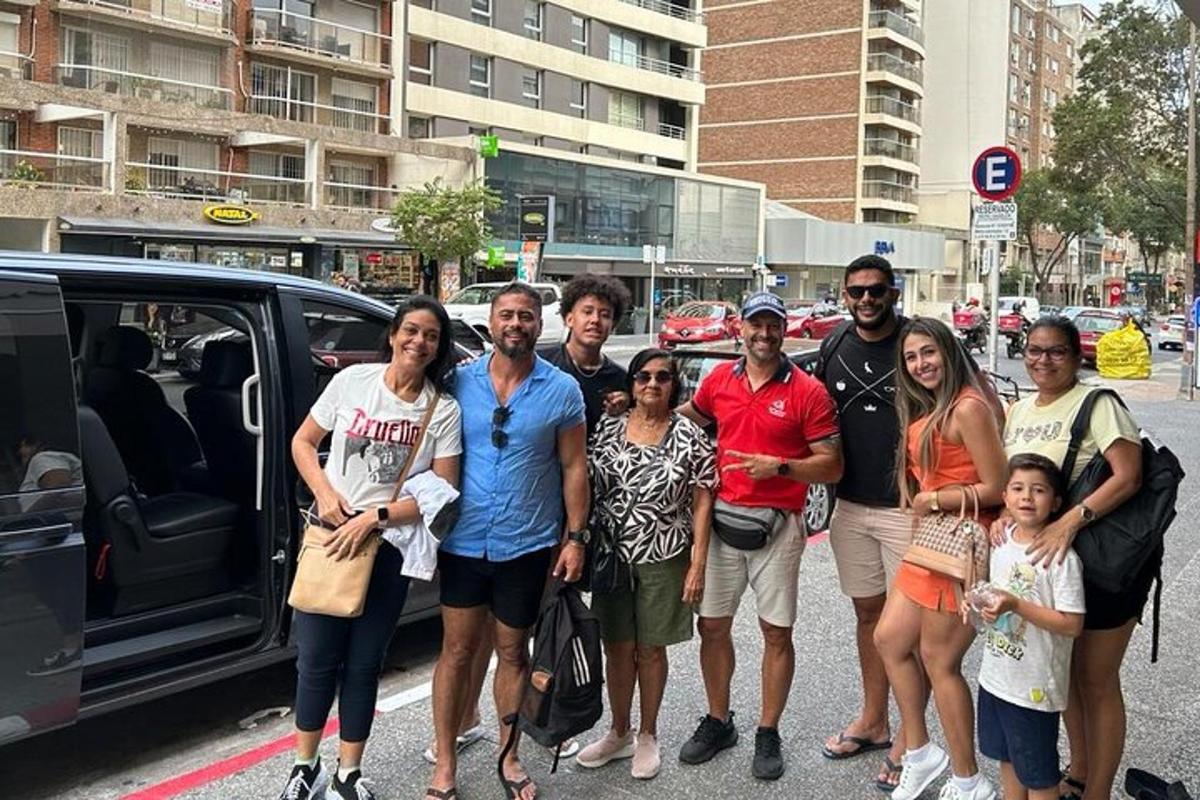 un grupo de personas de pie delante de un coche