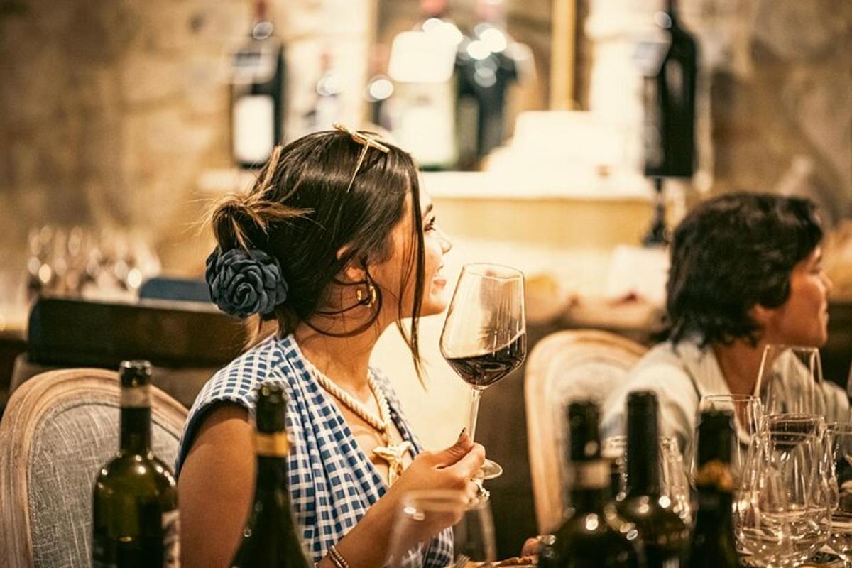 eine Frau sitzt mit einem Glas Wein an einem Tisch