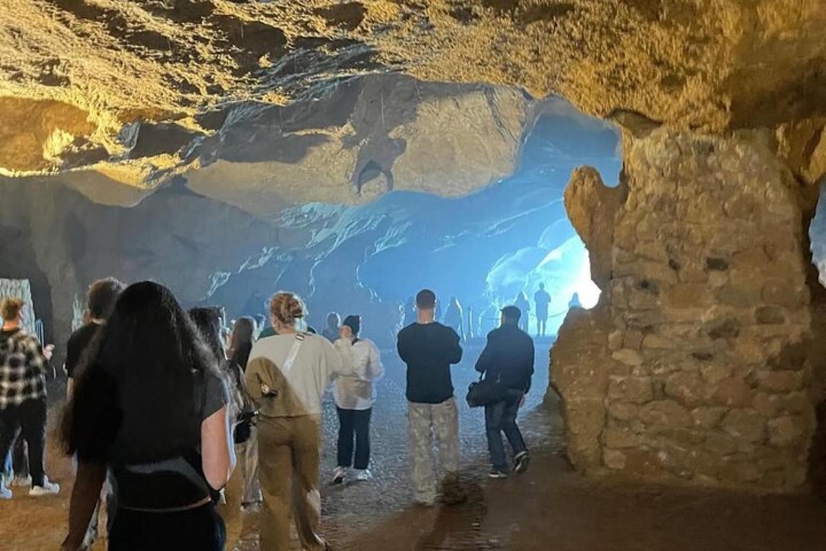 skupina lidí stojících ve velké jeskyni
