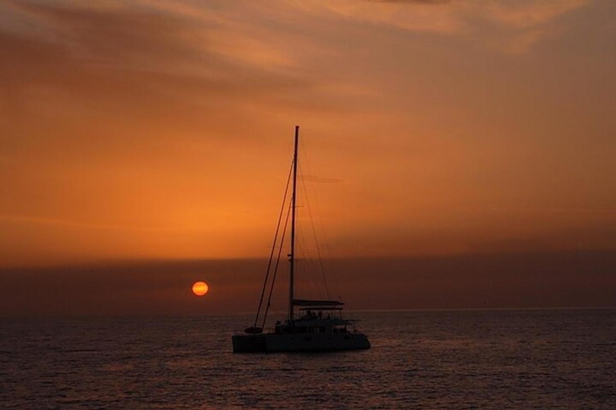 un vaixell a l'oceà amb el sol al fons