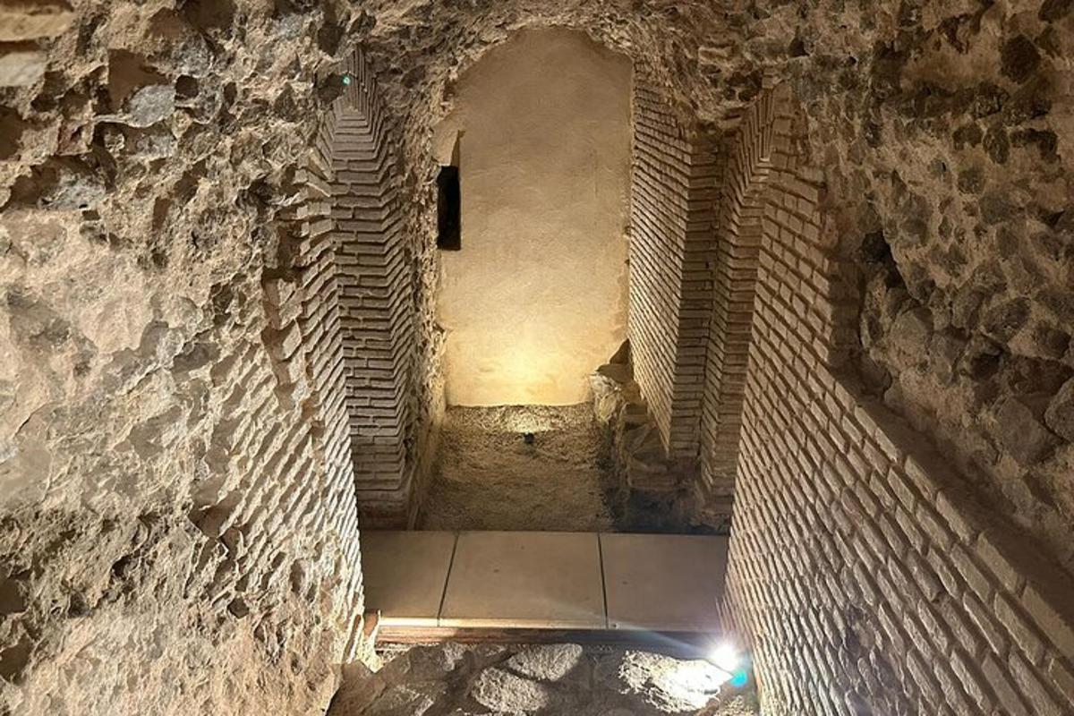 an alley way with a stone wall and a tunnel