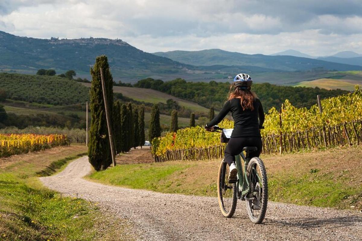 una donna che va in bicicletta lungo una strada sterrata