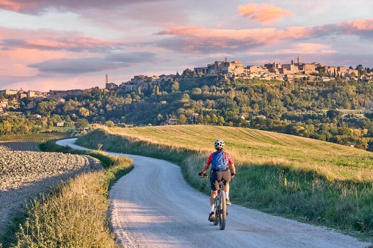 una persona che va in bicicletta lungo una strada sterrata