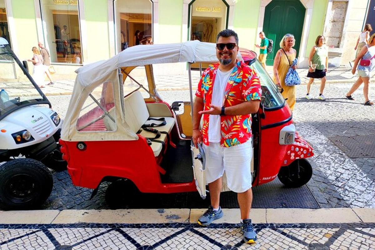 Muž stojí vedle malého golfového vozíku