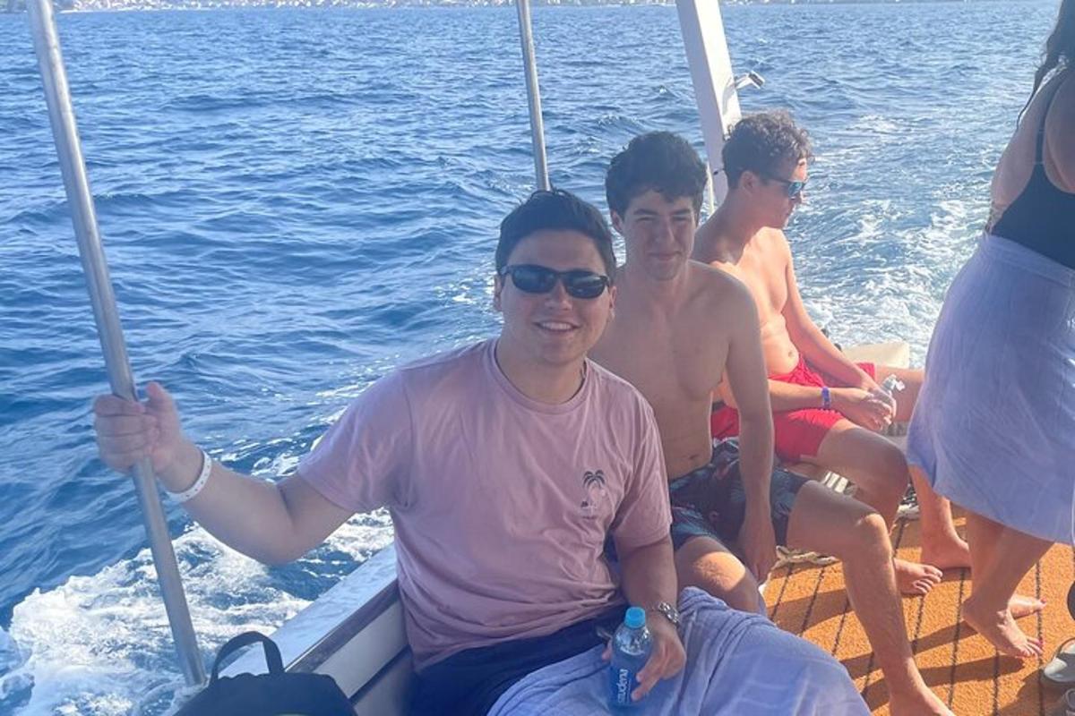 tres hombres sentados en un bote en el agua