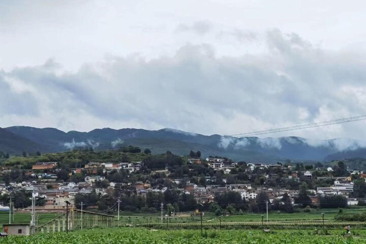 a town on a hill with mountains in the background