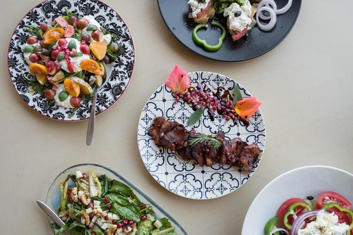 a table topped with plates of food and salads