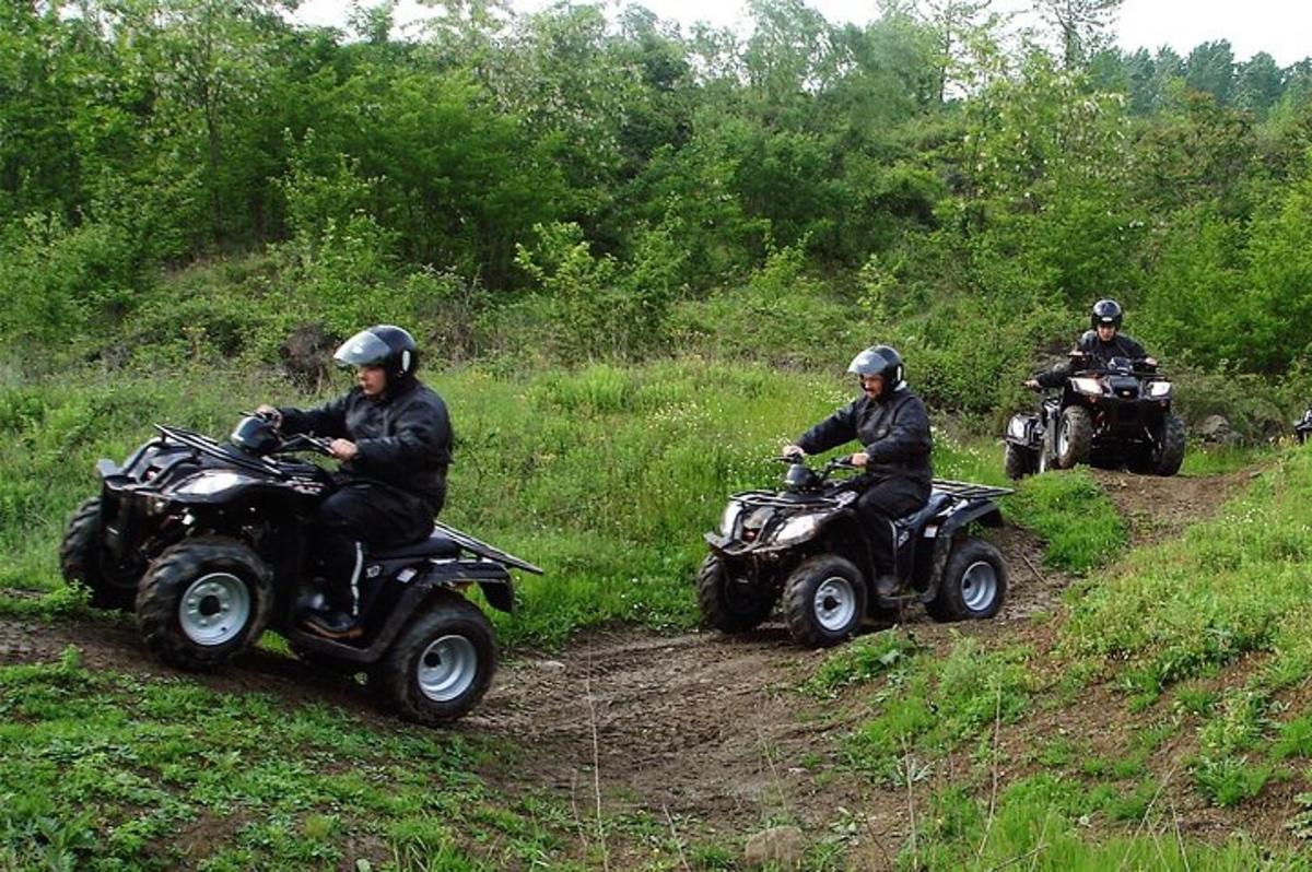 Tres personas en vehículos todo terreno conduciendo por un camino de tierra