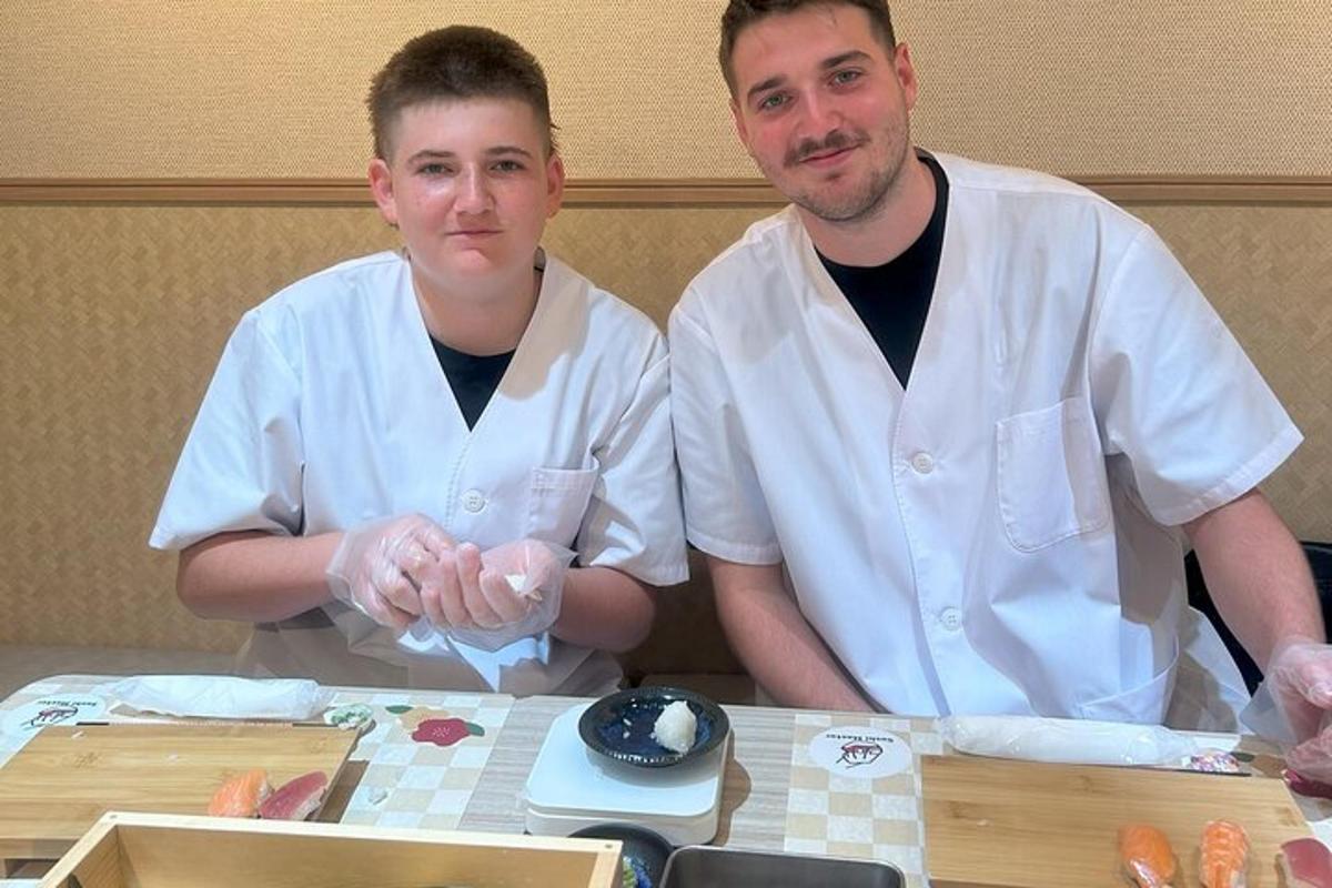 dois chefs em pé ao lado de uma mesa com comida