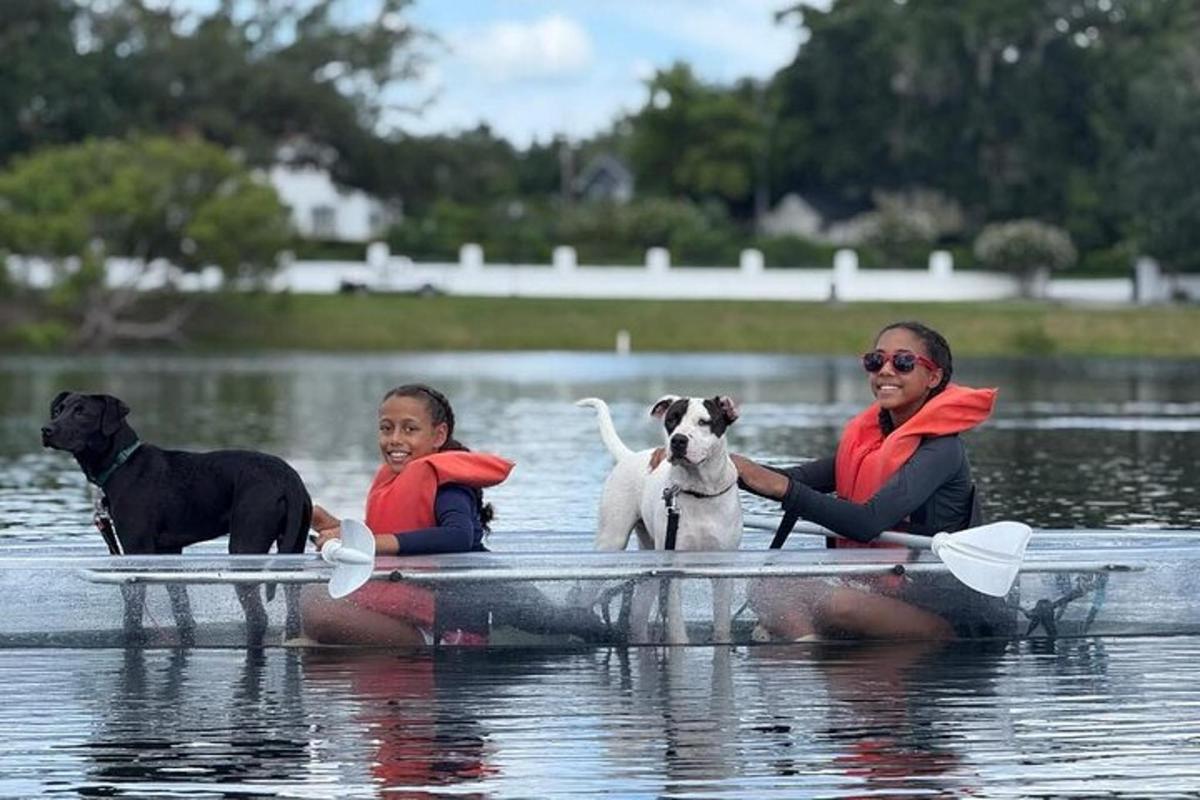 Dos mujeres y dos perros en un barco en el agua