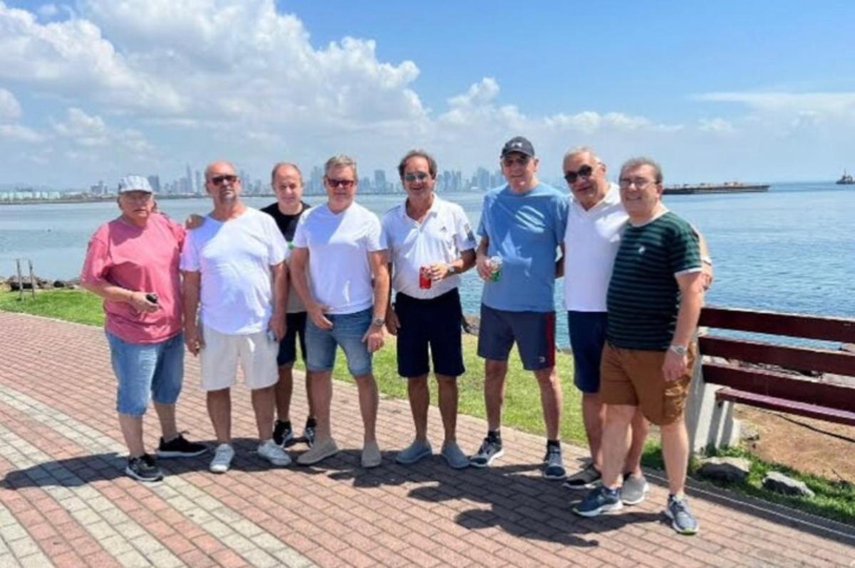 su kenarında fotoğraf çektiren bir grup insan