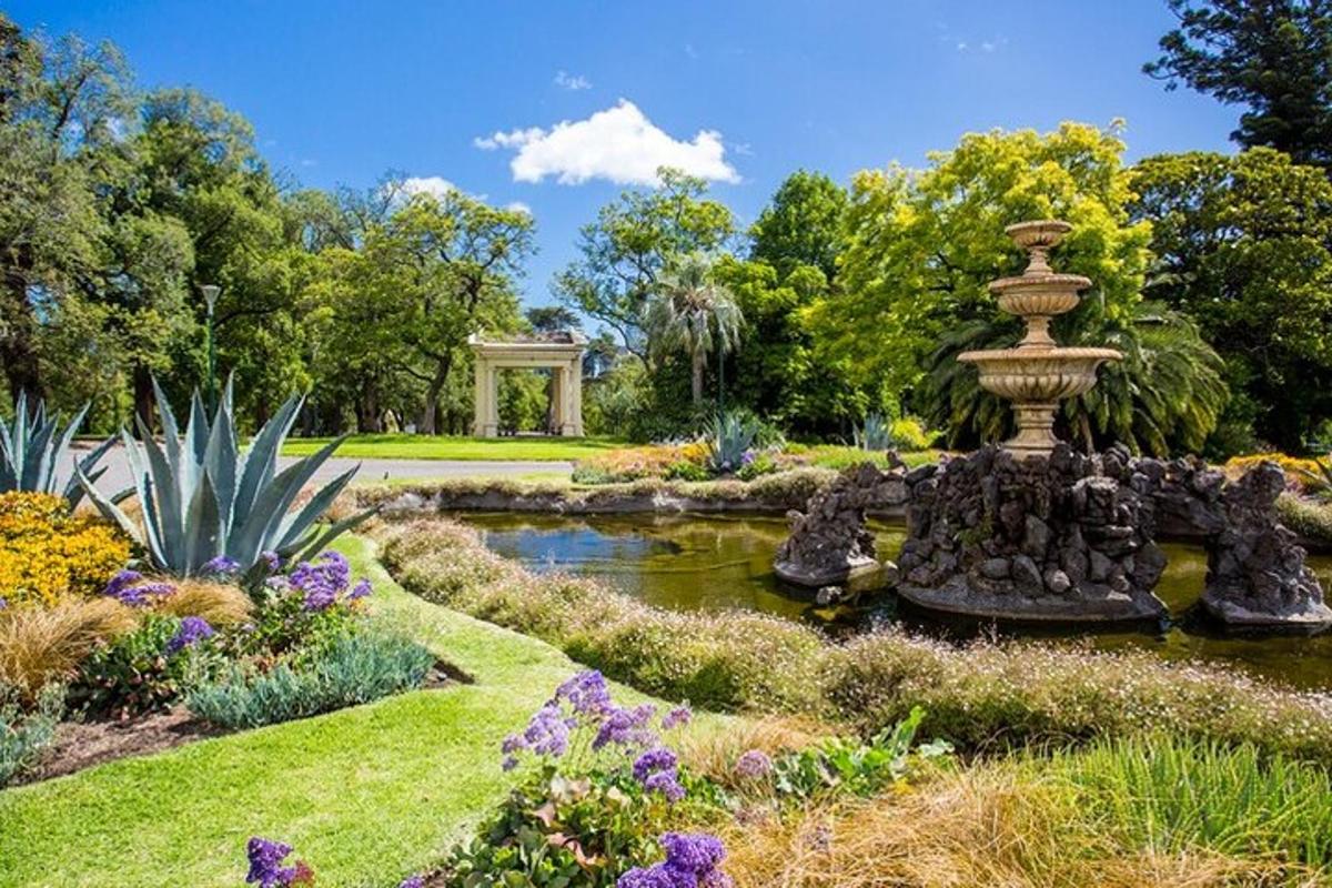 a garden with a fountain in the middle of a pond